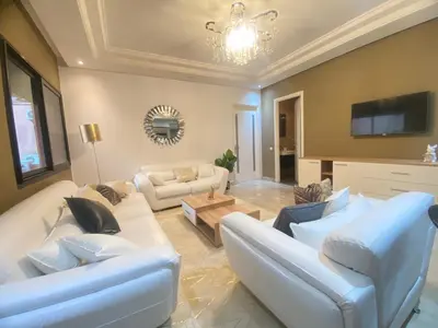 a living room with white couches and a tv at new and modern apartment in Marrakech