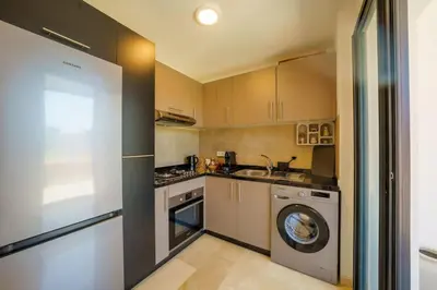 a kitchen with a washing machine and a washer at Appartement NOVA Noria in Marrakech