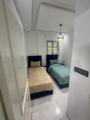 a bedroom with two beds and a shower in it at Luxury Apartment in Marrakesh two in Marrakech
