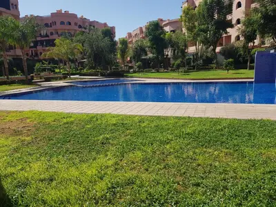 a swimming pool in the middle of a park with buildings at M32 Cosy Loft in Marrakech