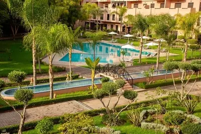 a swimming pool with palm trees and a building at M32 Cosy Loft in Marrakech