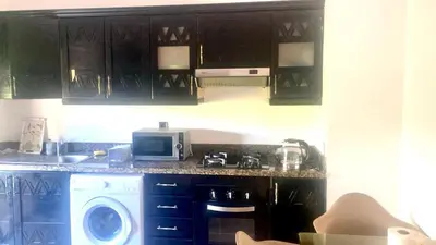 a kitchen with black cabinets and a washing machine at M32 Cosy Loft in Marrakech