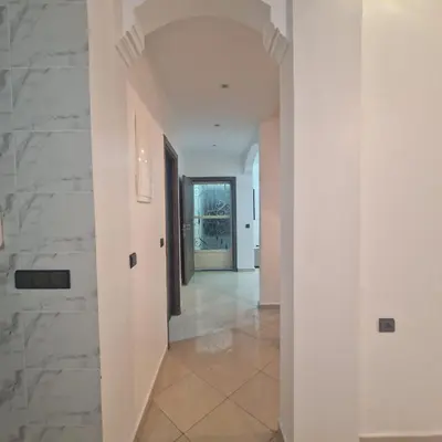 a hallway of a house with white walls and tile floors at New DUPLEX jardins d'anas- Avenue guemassa Near Airport in Marrakech