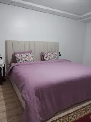 a bedroom with a large bed with purple sheets and pillows at New DUPLEX jardins d'anas- Avenue guemassa Near Airport in Marrakech