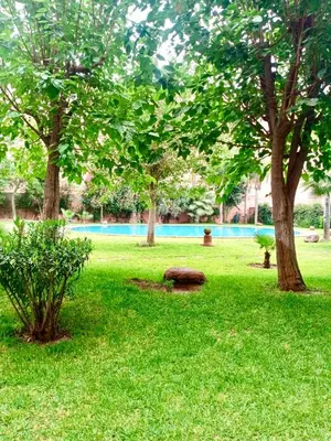 a park with trees and a bench in the grass at Beautiful Hivernage Apartment with Pool & Balcony, Near Attractions in Marrakech