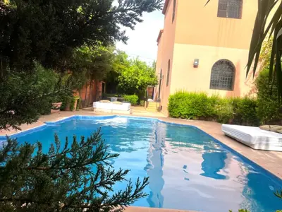 a swimming pool in a yard next to a building at Splendide villa de charme à Marrakech in Marrakech