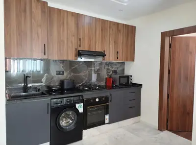 a kitchen with a stove and a washing machine at Charmant appartement en plein centre ville gueliz in Marrakech
