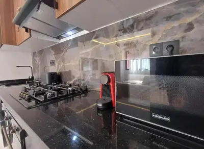 a kitchen with a stove and a microwave at Charmant appartement en plein centre ville gueliz in Marrakech