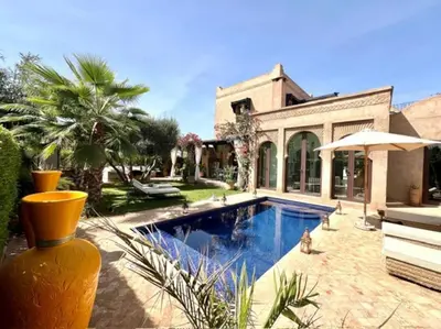 a house with a swimming pool in front of it at Villa LES LAURIERS, 4 suites, piscine privée, petit déjeuner compris in Marrakech