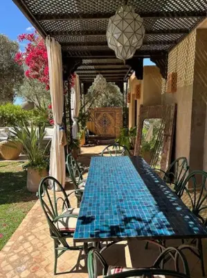 a blue table and chairs on a patio at Villa LES LAURIERS, 4 suites, piscine privée, petit déjeuner compris in Marrakech