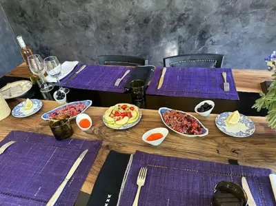 a wooden table with purple napkins and plates of food at Villa LES LAURIERS, 4 suites, piscine privée, petit déjeuner compris in Marrakech
