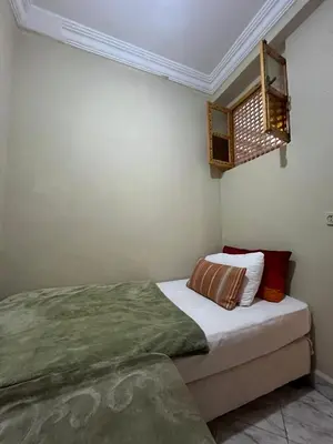 a bedroom with a bed with a green blanket at DarYOUSSEF 68 in Marrakech