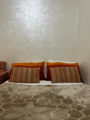 a bed with two pillows on top of it at DarYOUSSEF 68 in Marrakech