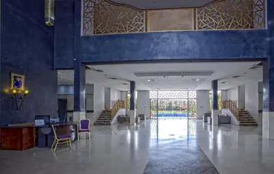 a lobby with blue walls and chairs and a table at Palm Appart Hôtel Marrakech in Marrakech