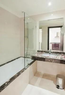 a bathroom with a tub and a glass shower at Palm Appart Hôtel Marrakech in Marrakech