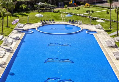 a swimming pool with three dolphins in the water at Palm Appart Hôtel Marrakech in Marrakech