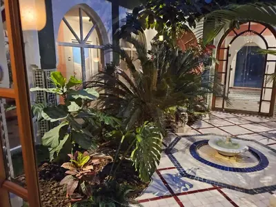 a room with a bunch of plants on a tile floor at Palais Oussoud in Sidi Yahia az Zaʼer