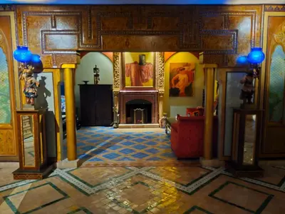 a living room with a fireplace and a tile floor at Palais Oussoud in Sidi Yahia az Zaʼer