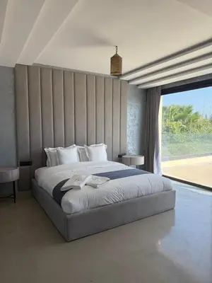 a bedroom with a large bed and a large window at AD Villa in Marrakech