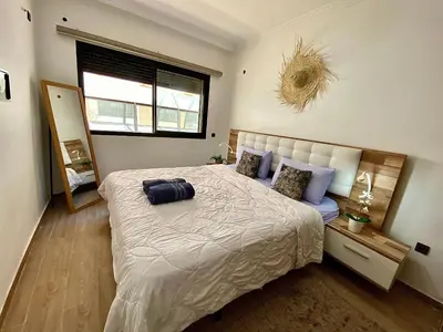 a bedroom with a large bed and a window at apparte 2 chambres luxe en face la gare gueliz in Marrakech