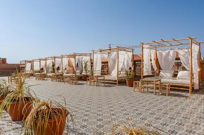 a row of tents with chairs and potted plants at Piscine chauffée - Sauna - Hammam - Appart Coeur de Gueliz in Marrakech