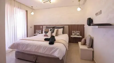 a bedroom with a large bed with white sheets and pillows at Piscine chauffée - Sauna - Hammam - Appart Coeur de Gueliz in Marrakech