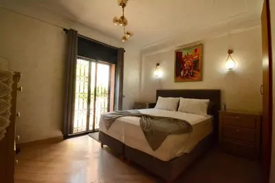 a bedroom with a bed and a large window at Modern Garden-Level Apartment with Pool & Jacuzzi in Marrakech
