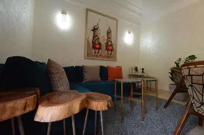 a living room with a blue couch and two tables at Modern Garden-Level Apartment with Pool & Jacuzzi in Marrakech