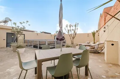a wooden table and chairs on a patio at Free People Riad and Spa in Marrakech