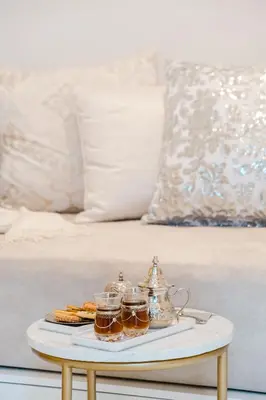 a tray with two cups of tea and cookies on a bed at Free People Riad and Spa in Marrakech