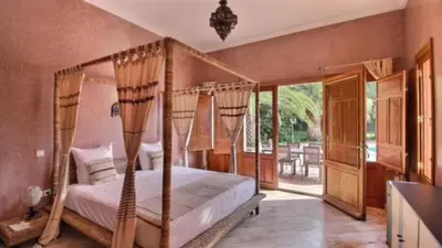 a bedroom with a canopy bed and a patio at Villa Dauphin in Marrakech