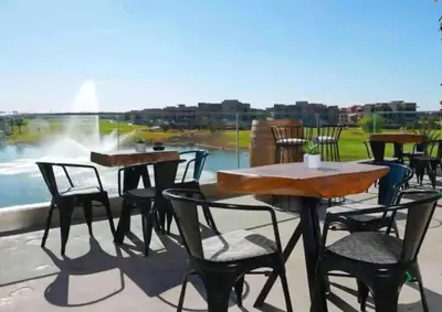 a patio with tables and chairs and a fountain at Prestigious Apartment in Marrakech