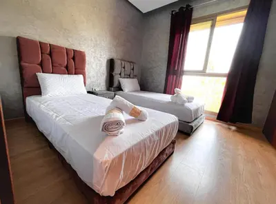 a bedroom with two beds and a window at Prestigious Apartment in Marrakech