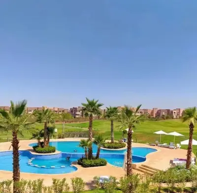 an aerial view of a resort pool with palm trees at Prestigious Apartment in Marrakech