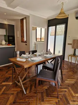 a dining room with a wooden table and chairs at Luxueux Duplex rooftop en plein cœur de Majorelle in Marrakech