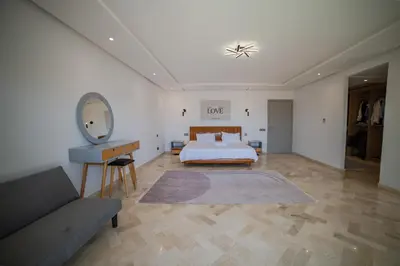 a bedroom with a bed and a couch and a mirror at Villa in Marrakesh in Marrakech