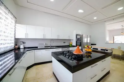 a kitchen with white cabinets and a black counter top at Villa in Marrakesh in Marrakech