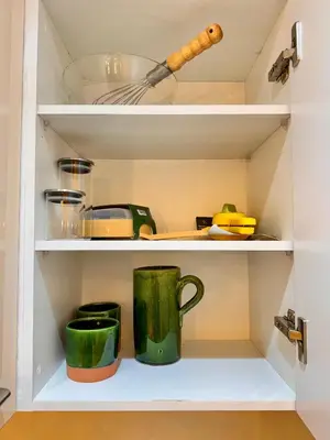 a cupboard with two green coffee mugs in it at Pearl Garden Studio Luxueux Piscine Sunny Terrasse in Marrakech