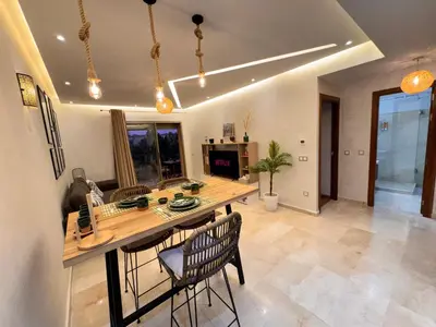 a kitchen with a wooden table and chairs at Pearl Garden Studio Luxueux Piscine Sunny Terrasse in Marrakech