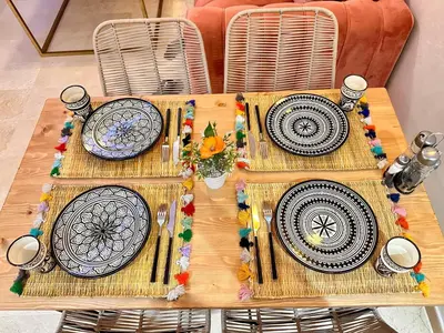 a wooden table with plates and utensils on it at PEARL GARDEN Luxueux Studio Chic Piscine Terrasse Netflix IPTV Parking in Marrakech