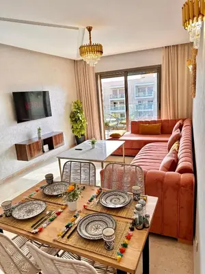 a living room with a couch and a table at PEARL GARDEN Luxueux Studio Chic Piscine Terrasse Netflix IPTV Parking in Marrakech