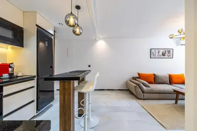 a kitchen and living room with a table and a couch at Luxurious City Apartment in Marrakech