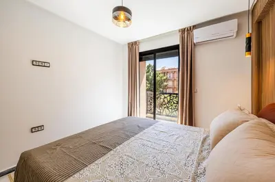 a bedroom with a bed and a large window at Luxurious City Apartment in Marrakech