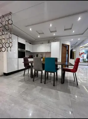 a kitchen with a dining room table and chairs at Bel Appartement Hivernage-Gueliz 2 chambres in Marrakech