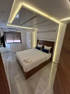 a bedroom with a large white bed with blue pillows at Bel Appartement Hivernage-Gueliz 2 chambres in Marrakech