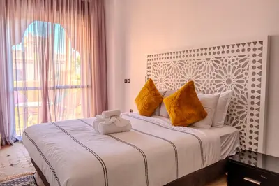 a bedroom with a large bed with yellow pillows at Luxury Villa with Pool, Garden & Gated Security in Marrakech