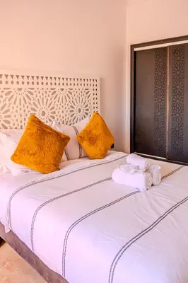 a white bed with two towels on top of it at Luxury Villa with Pool, Garden & Gated Security in Marrakech