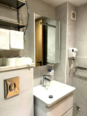 a white bathroom with a sink and a mirror at Appartement luxueux, cosy & confortable in Marrakech