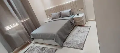 a bedroom with a bed and a window with rugs at Chez bousfyha 2 in Marrakech