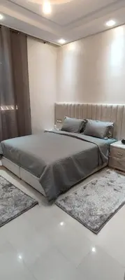 a large bed in a room with rugs on the floor at Chez bousfyha 2 in Marrakech